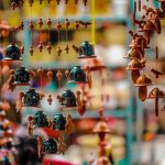 Vibrant hanging bells and ornaments in a pottery market stall, showcasing cultural artistry.
